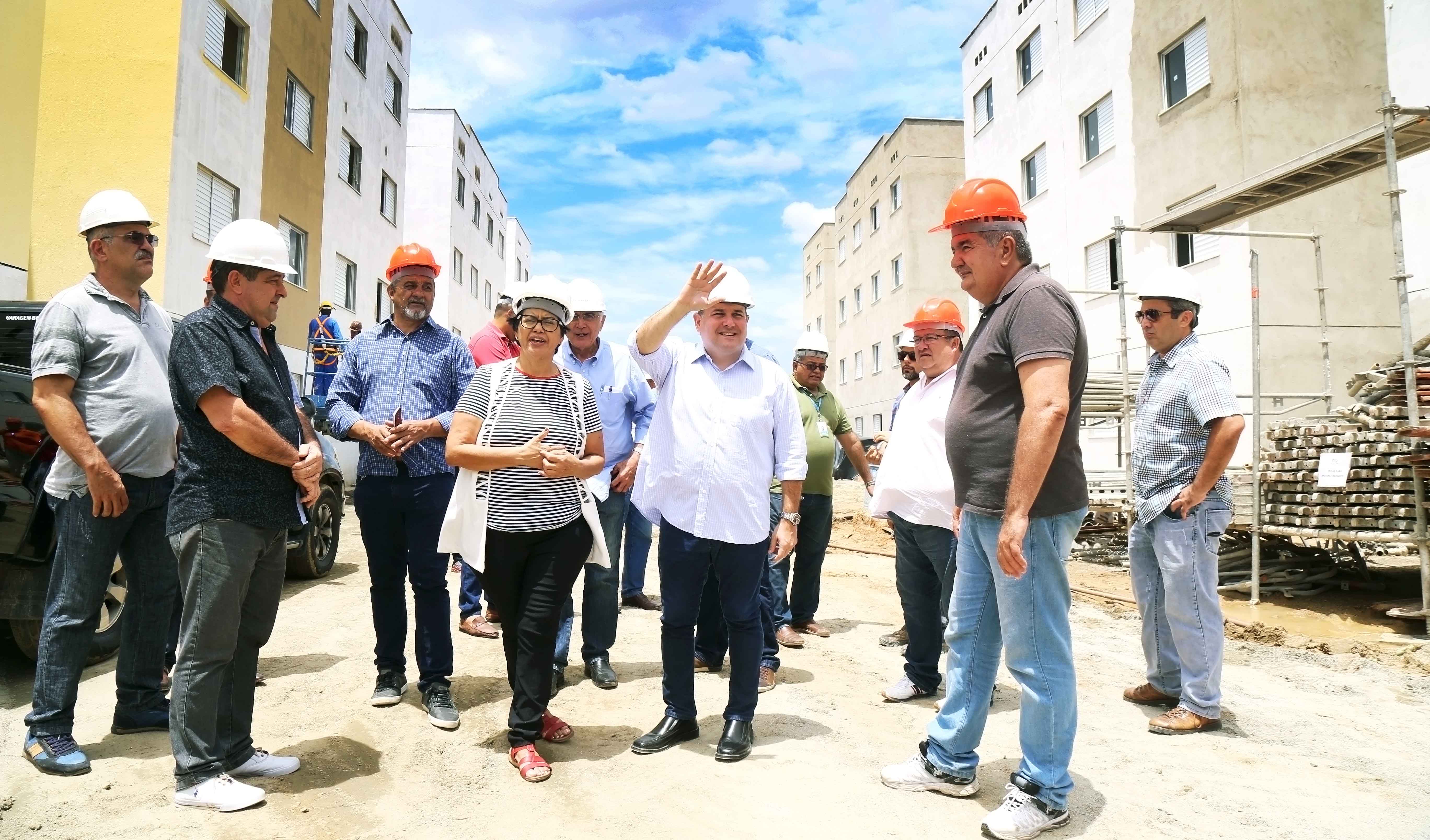 várias pessoas caminham no canteiro de obras de apartamentos